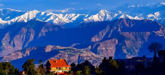 Upper Bakrota, Dalhousie with forested hills and snow-covered Himalayan ranges in the background